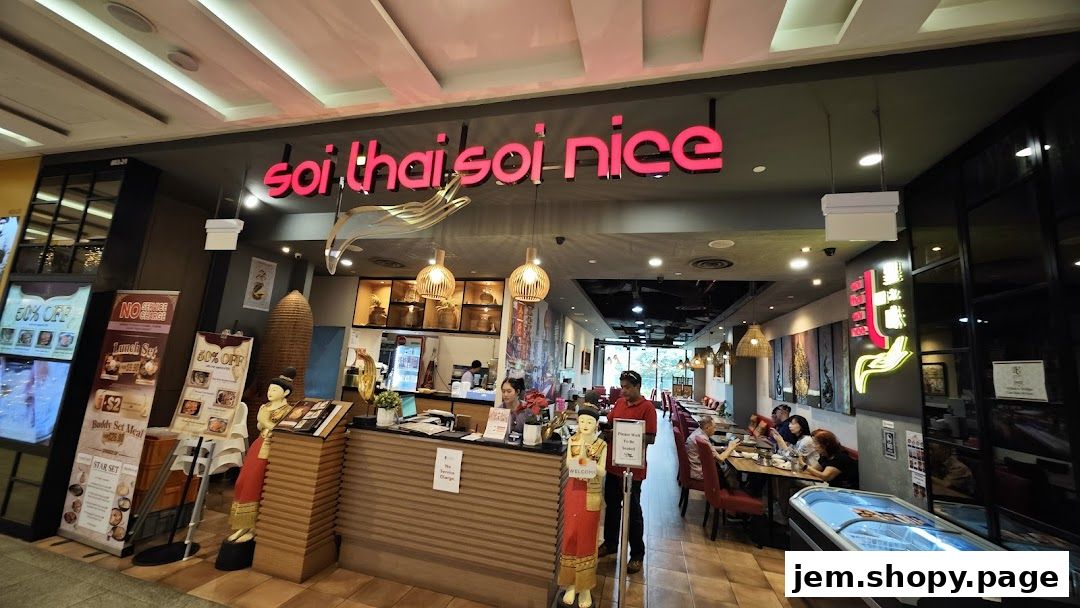 The exterior of Soi Thai Soi Nice restaurant with promotional posters and seating visible inside.