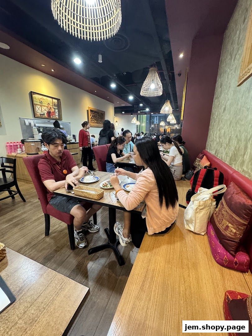 Diners enjoy a meal at Soi Thai Soi Nice JEM, with a warm and inviting ambiance.