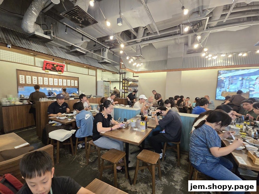 Diners enjoy meals inside a bustling Song Fa Bak Kut Teh restaurant with traditional decor.