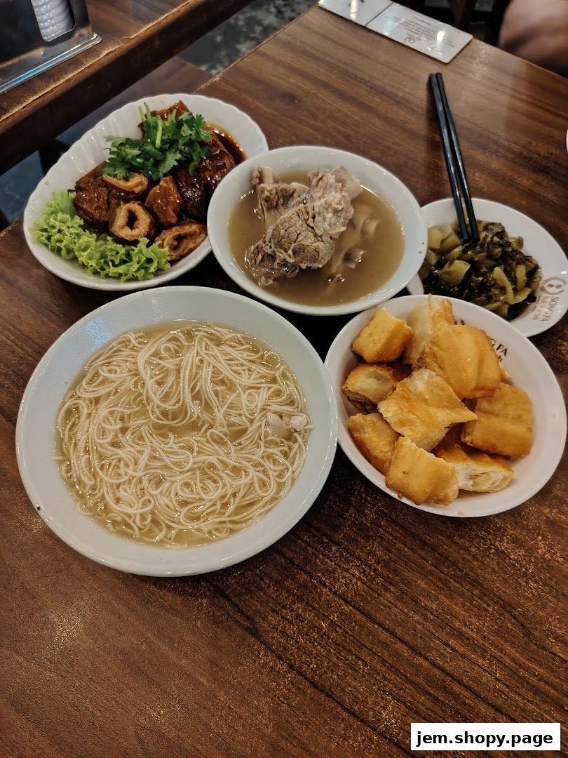 A spread of delicious Song Fa Bak Kut Teh dishes including noodles, pork ribs, and fried dough.
