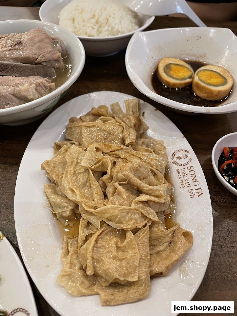 A close-up of a meal at Song Fa Bak Kut Teh, featuring braised peanuts, preserved eggs, and rice.