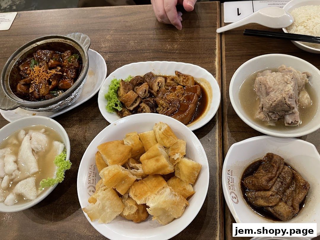 A table laden with various dishes from Song Fa Bak Kut Teh, including pork ribs, braised pork, and fried dough.