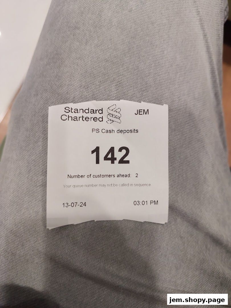A queue ticket from Standard Chartered Bank for PS Cash deposits.