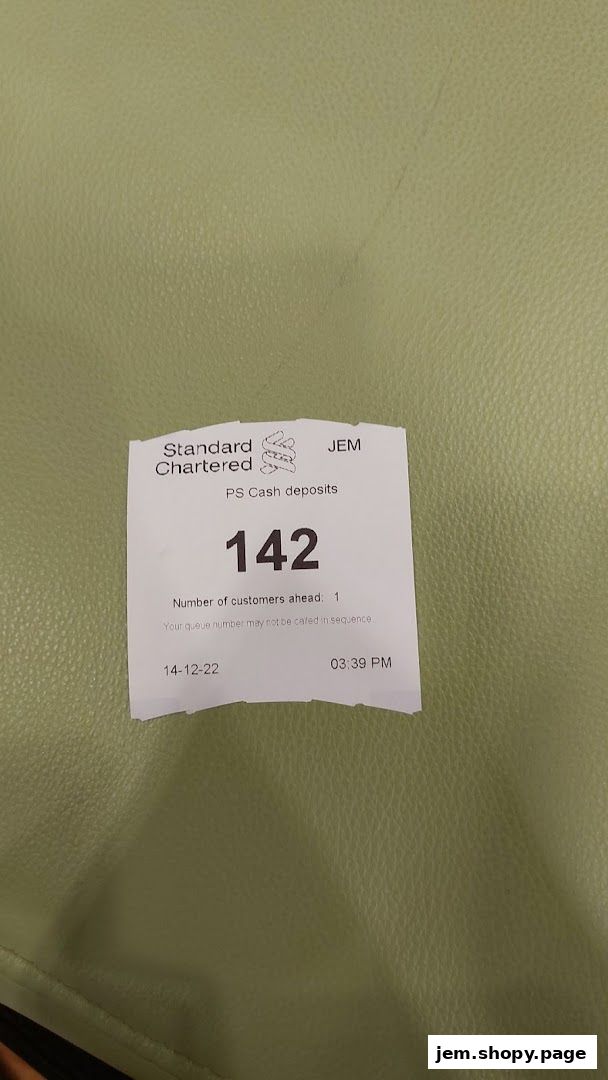A queue ticket from Standard Chartered Bank for PS Cash deposits.