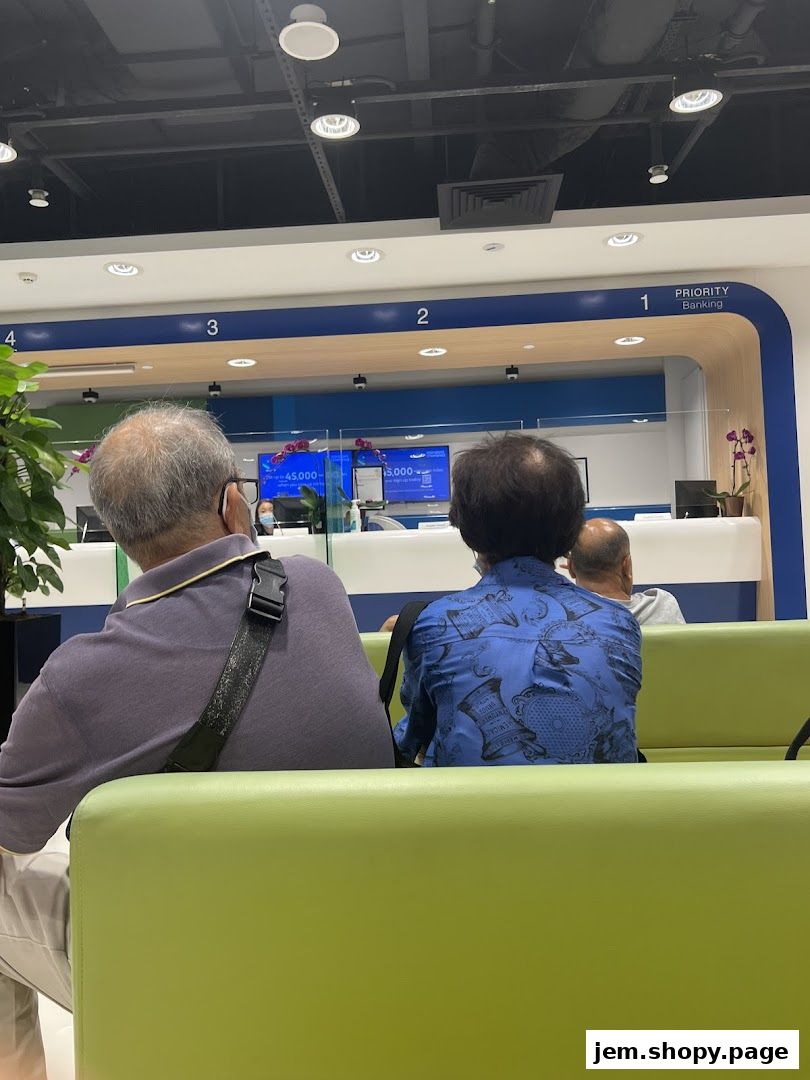 Customers wait in a modern bank lobby with numbered service counters.
