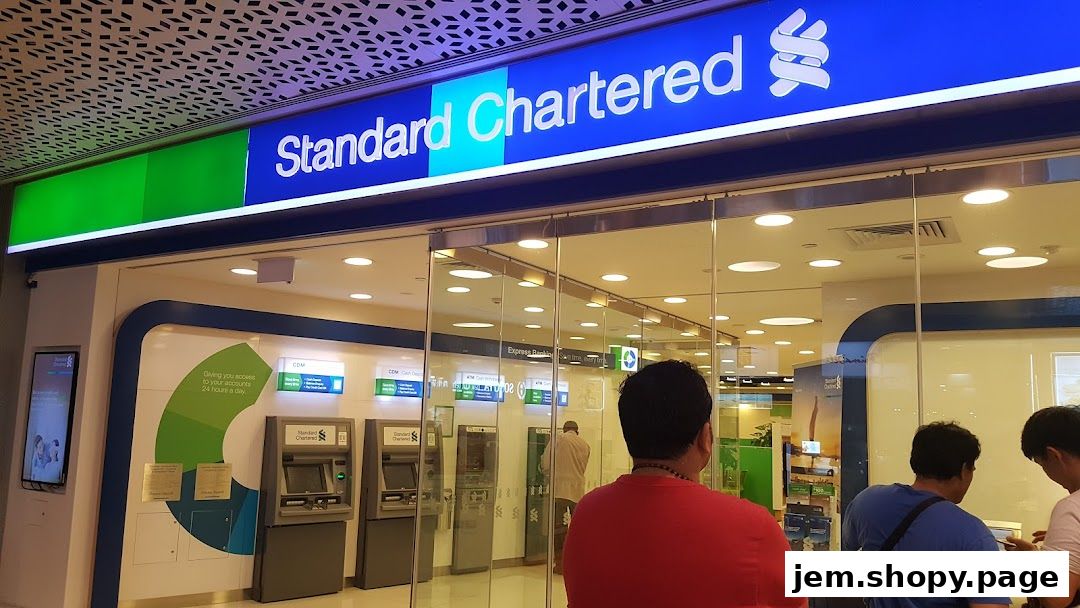 Exterior of a Standard Chartered Bank branch with ATMs and glass doors.