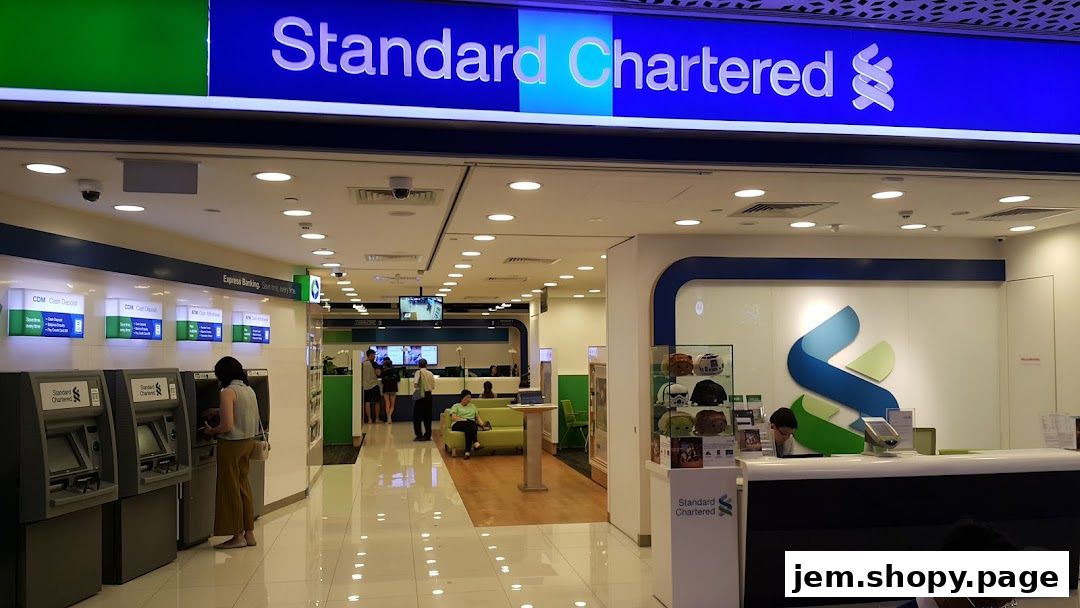 Exterior view of a Standard Chartered Bank branch with ATMs and a service counter.