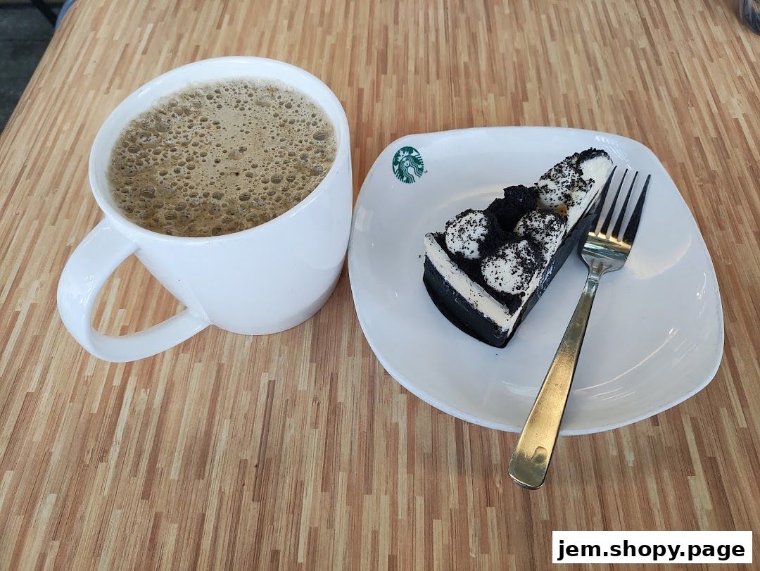 A cup of coffee and a slice of black and white cake on a wooden table.