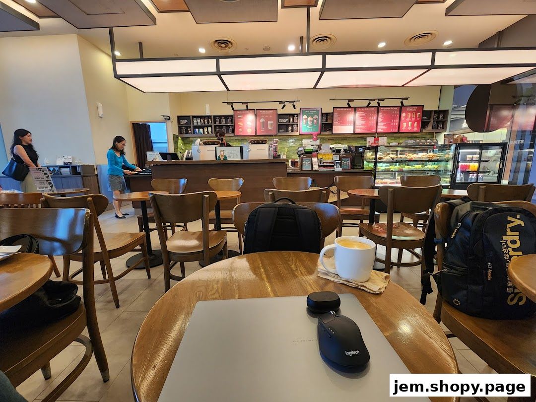 Interior view of a Starbucks cafe with seating, counter, and display cases.