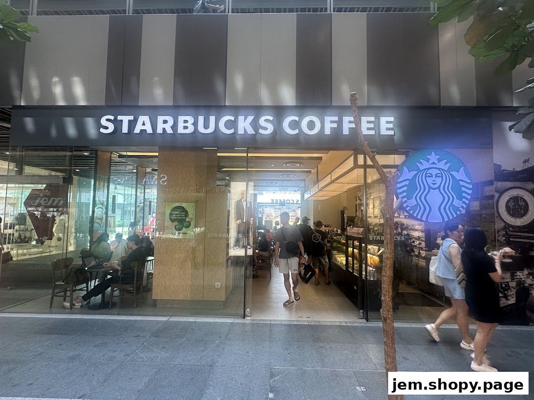 The exterior of a Starbucks coffee shop with people entering and sitting inside.