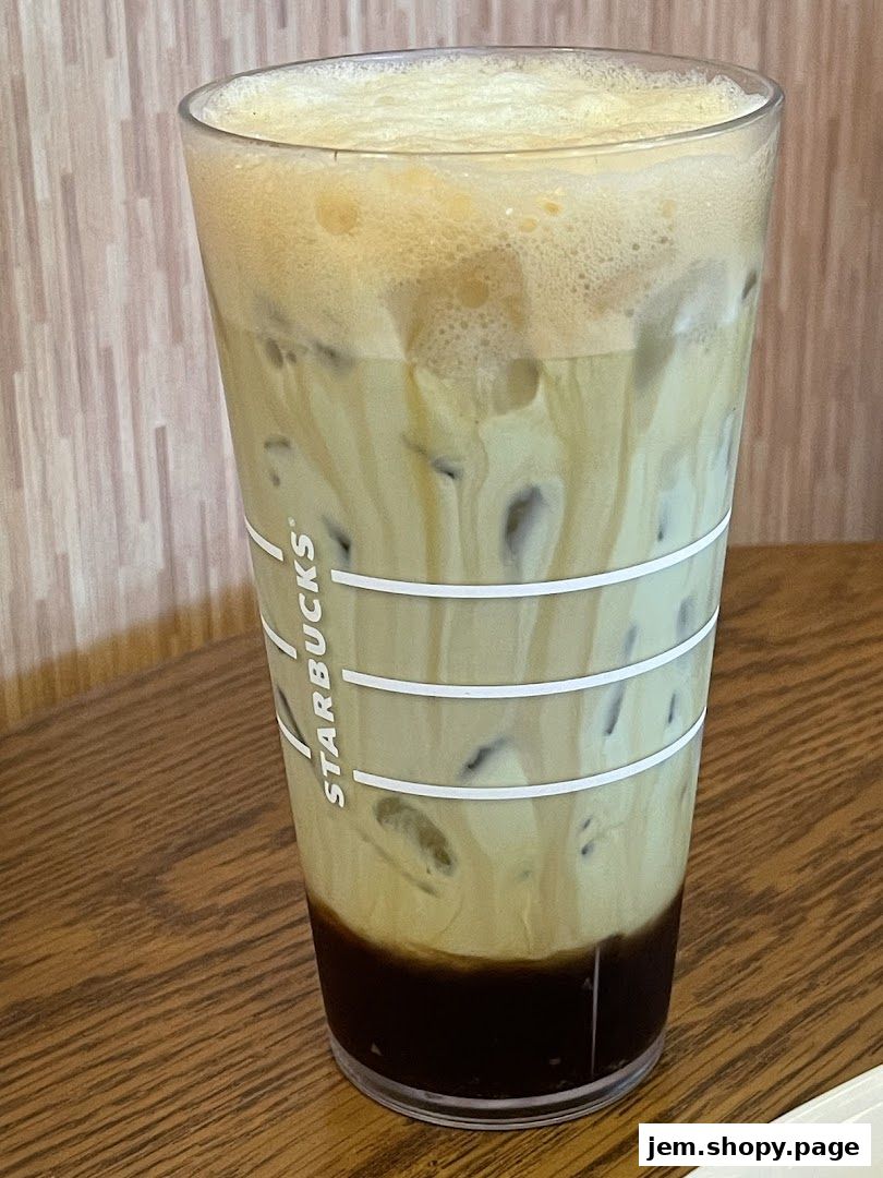 A refreshing iced coffee drink with layers of cream and dark coffee in a Starbucks cup.