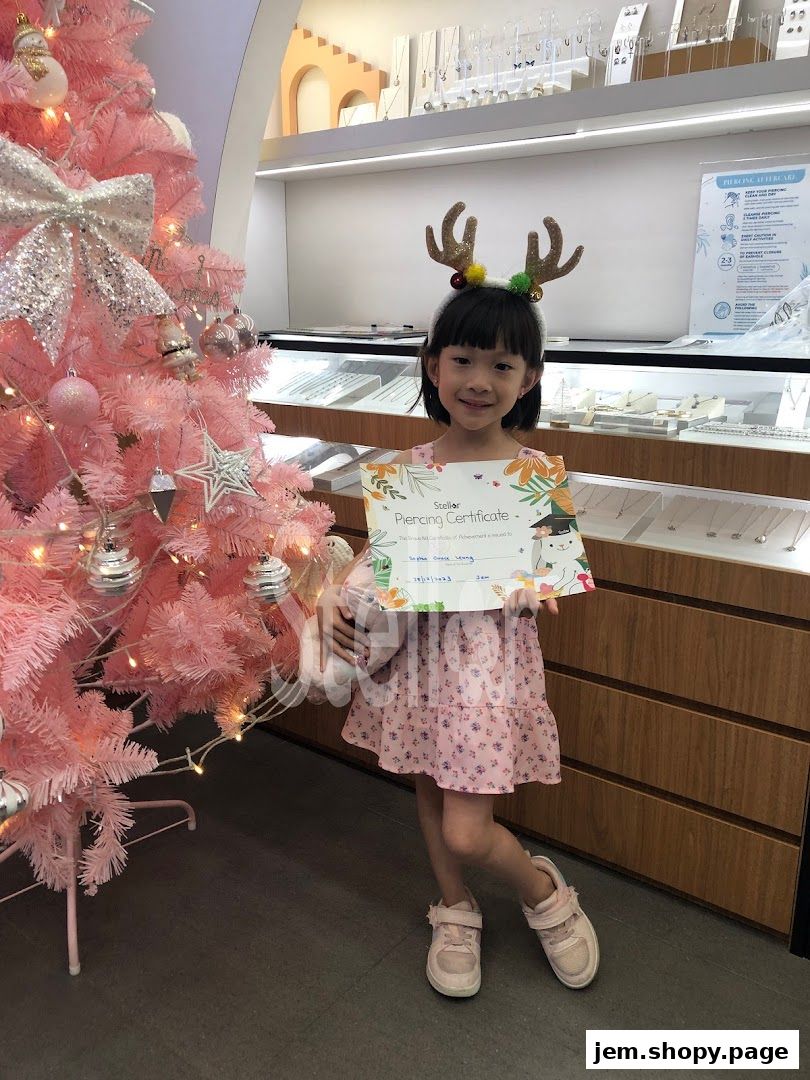 A young girl in festive attire holds a piercing certificate in a jewelry store.