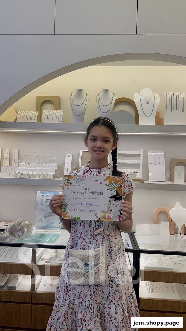 A young girl proudly holds a piercing certificate in a jewelry store.
