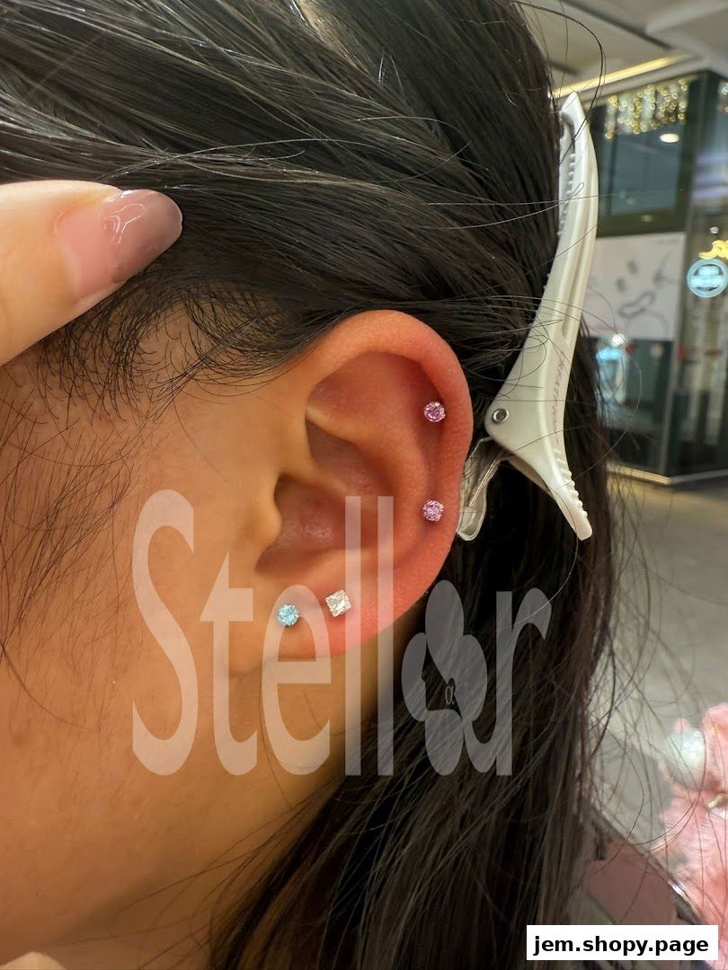 Close-up of a person's ear with multiple sparkling piercings.