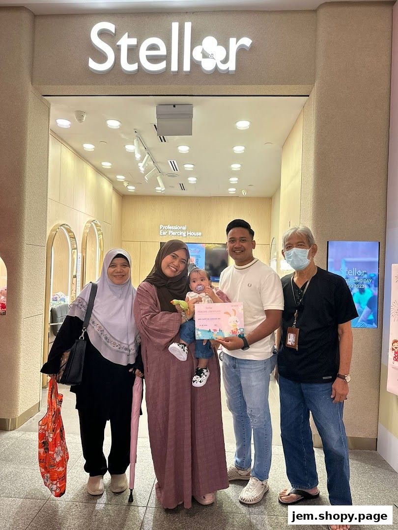 A family poses in front of Stellar Jem Ear Piercing Jewellery with a certificate.