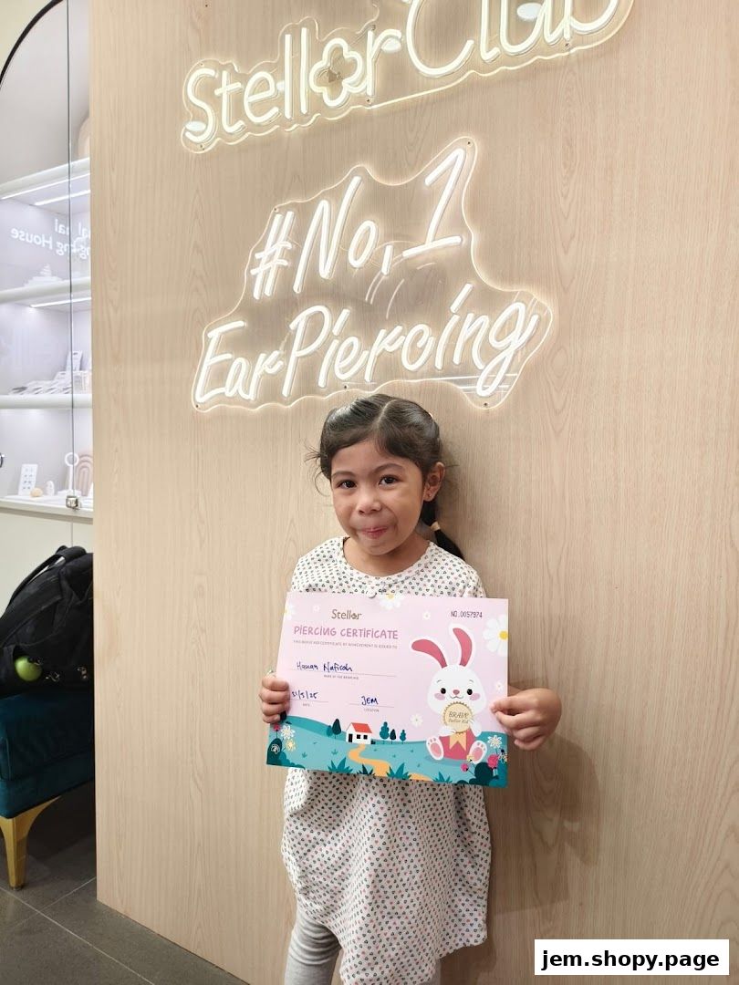 A young girl proudly holds a piercing certificate in front of a neon sign.