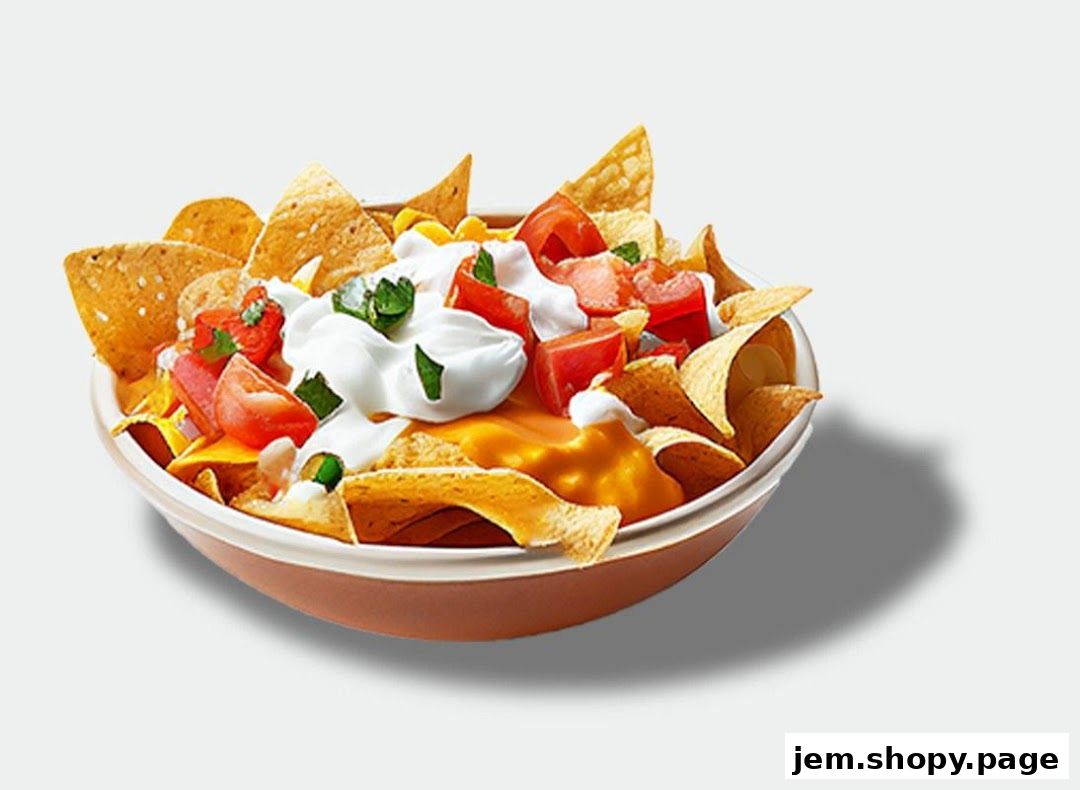 A bowl of loaded nachos with cheese, sour cream, tomatoes, and cilantro.
