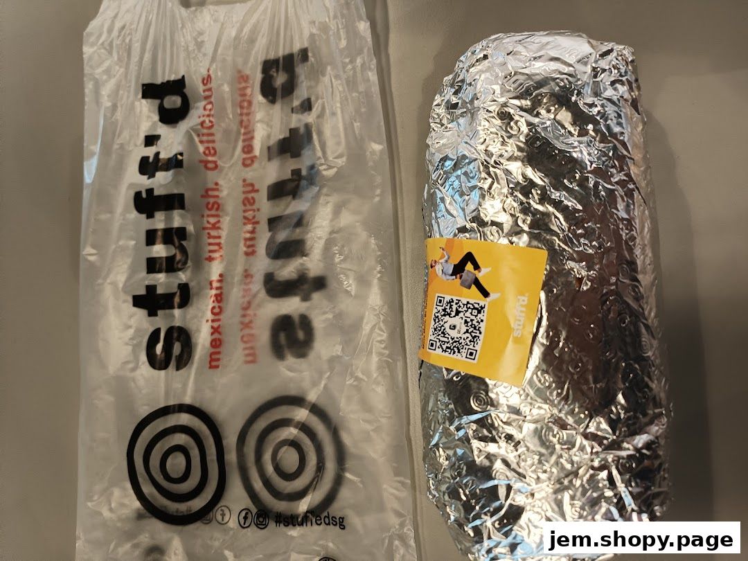 A Stuffd branded bag and a foil-wrapped burrito with a QR code sticker.