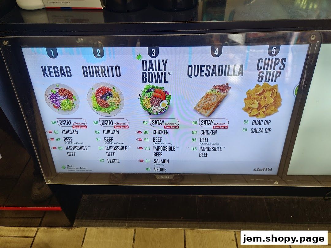 A digital menu board displaying various food options like kebabs, burritos, bowls, quesadillas, and chips with dips.