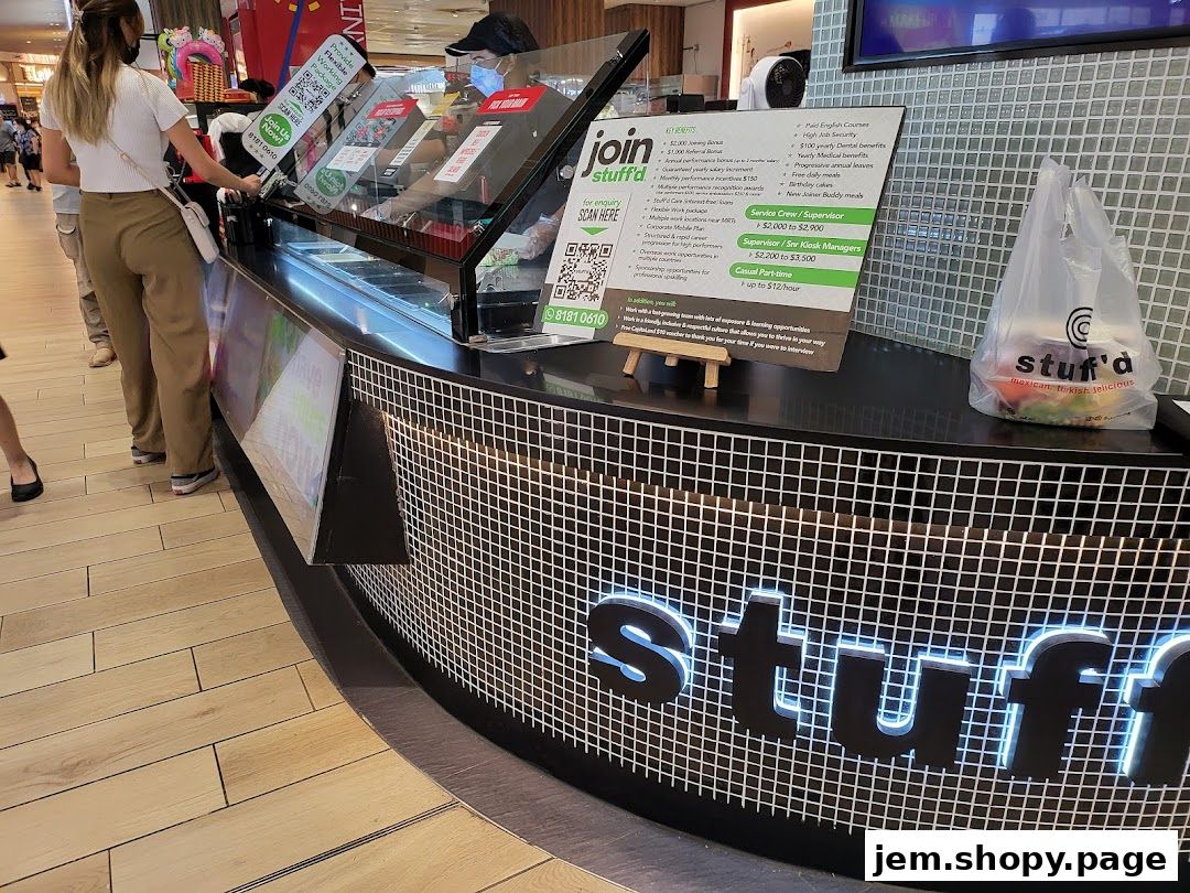 A Stuff'd shop counter with a recruitment sign and a takeaway bag.