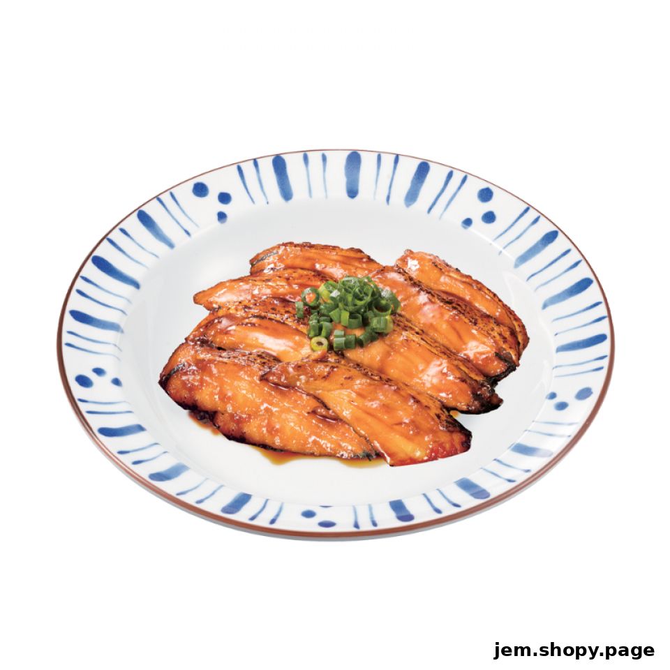 A plate of glazed pork belly with chopped green onions on top.