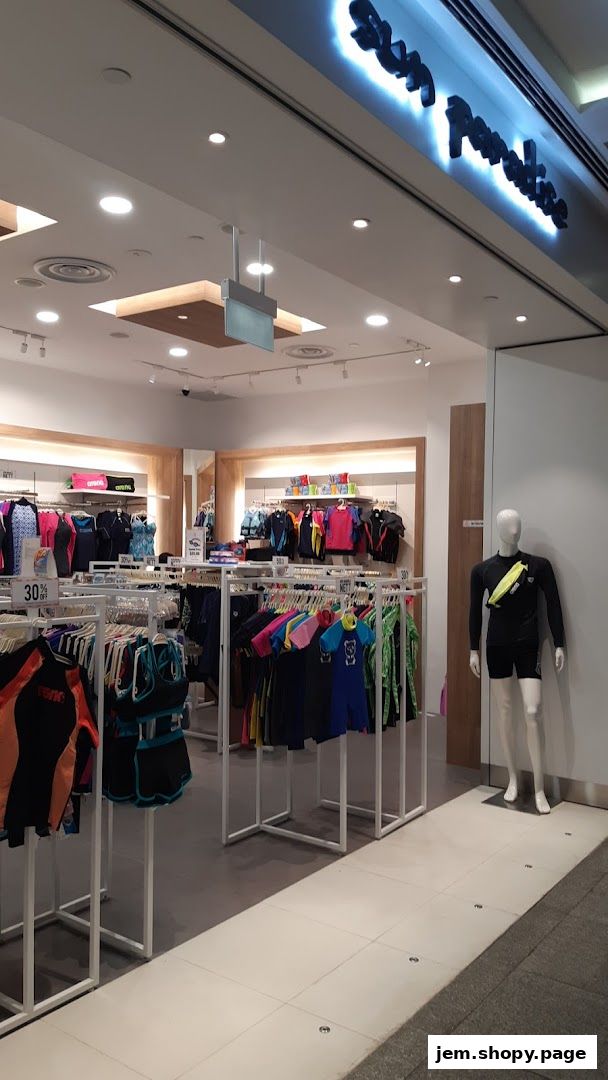 The entrance of Sun Paradise, a shop selling swimwear and beachwear, with clothing displayed on racks and a mannequin.