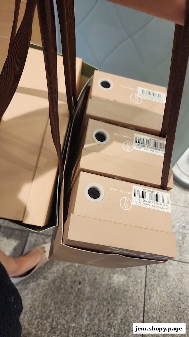 A person carrying shopping bags filled with shoe boxes from Sunday Staples.