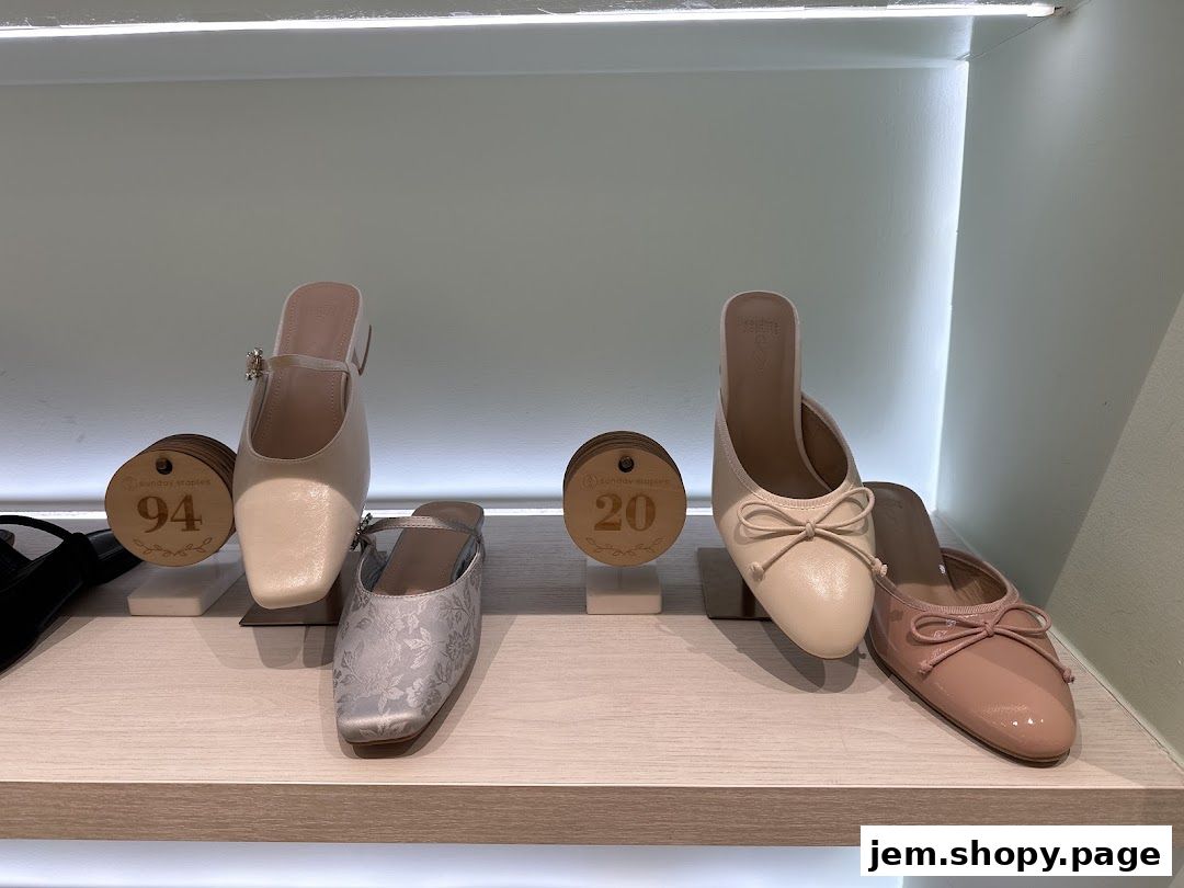 A display of elegant women's shoes, including mules and flats, on a shelf.