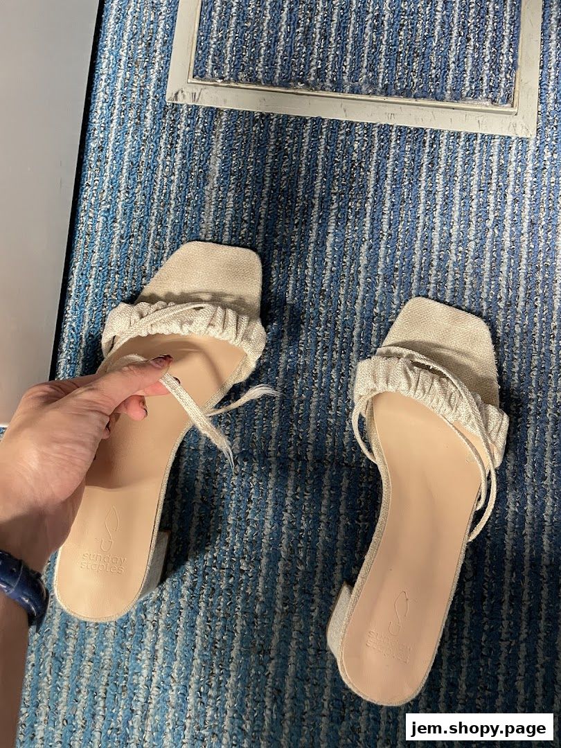 A pair of light-colored sandals with ruffled straps from Sunday Staples.