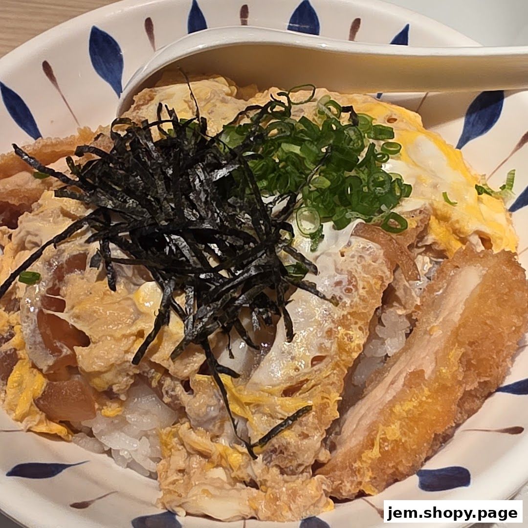 A close-up of a delicious katsudon dish with rice, egg, and crispy pork.