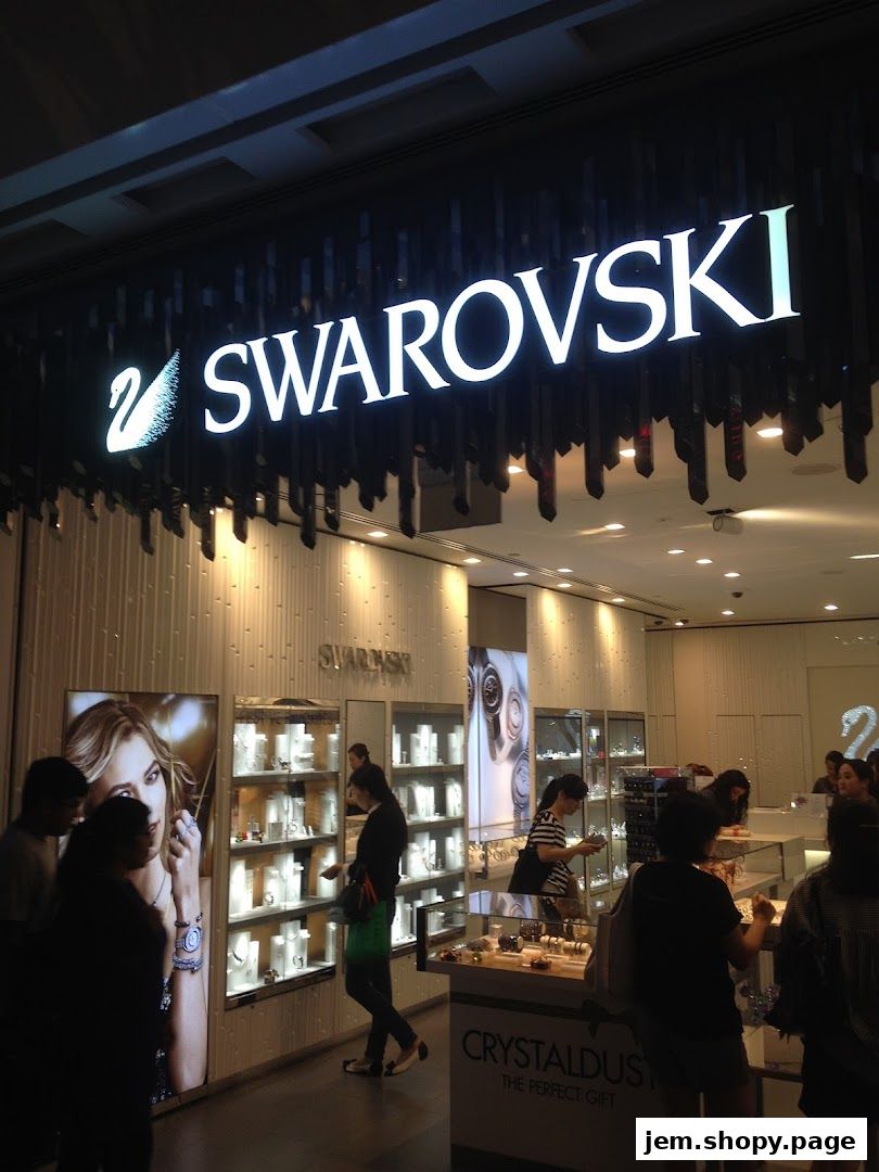 The illuminated Swarovski store sign above a display of sparkling jewelry and accessories.