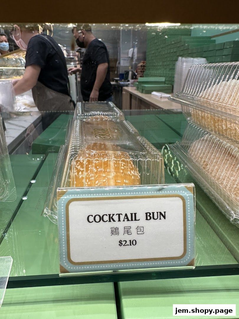 A close-up of a 'Cocktail Bun' with its price displayed at Tai Cheong Bakery.