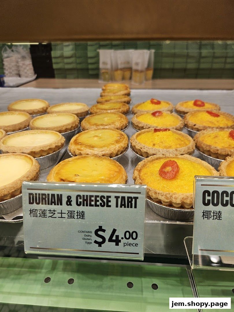 A display of freshly baked durian and cheese tarts, with a price tag visible.