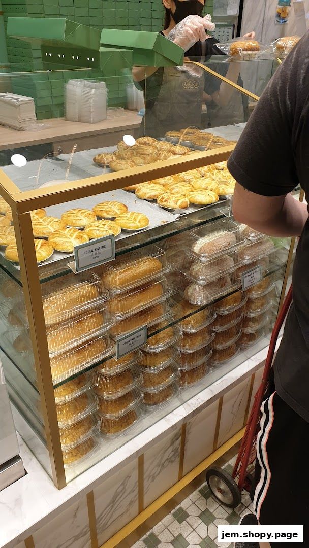 A display case filled with various baked goods, including pies and buns, at Tai Cheong Bakery.
