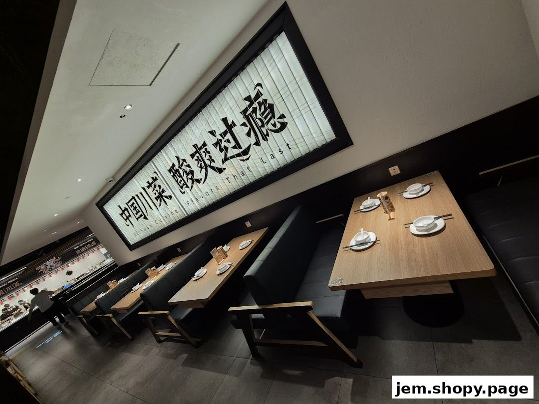 Interior of a restaurant with booth seating and a large illuminated sign.
