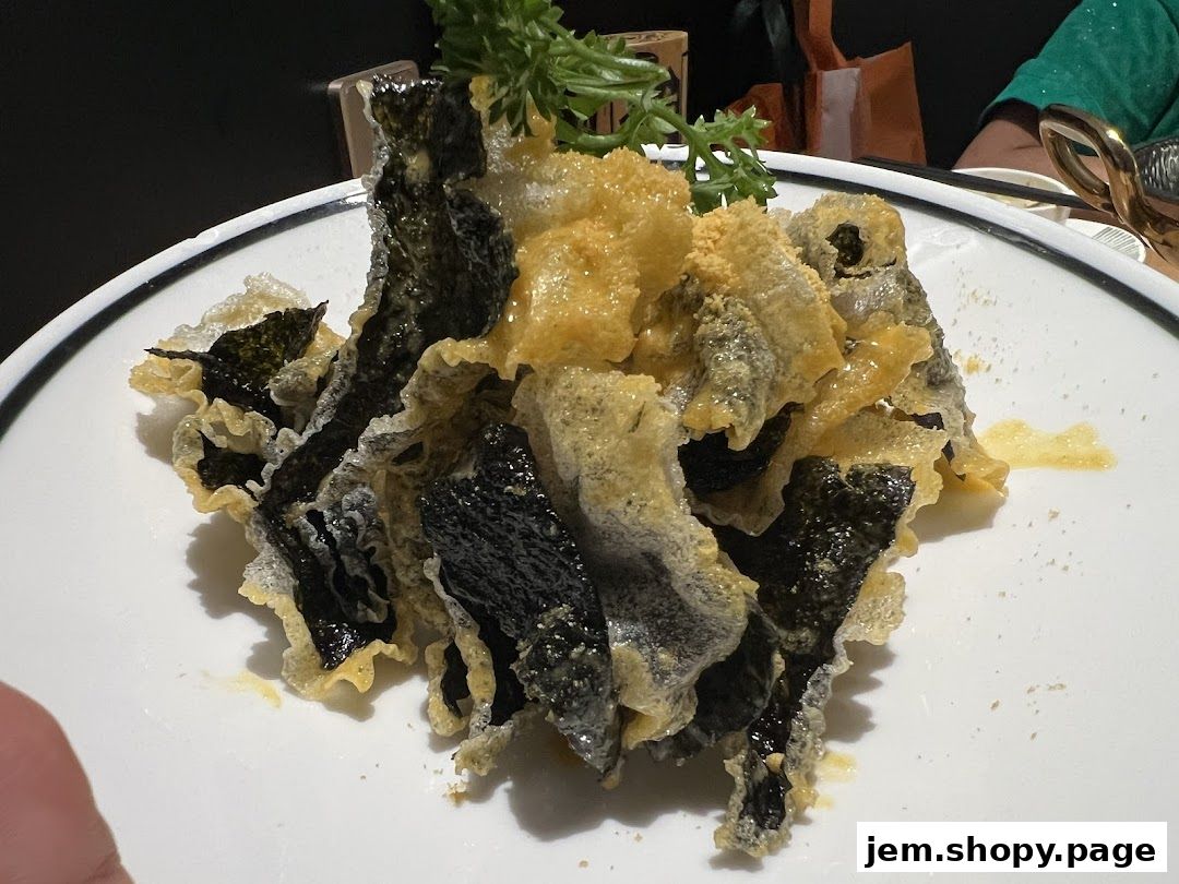 A close-up of crispy fried seaweed and fish skin served on a white plate.