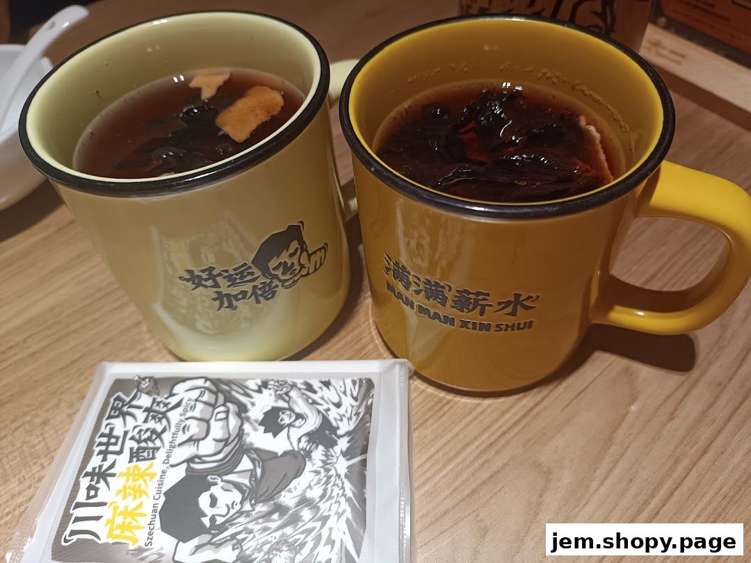 Two mugs of hot beverages with dried ingredients and a packet of Szechuan cuisine seasoning.