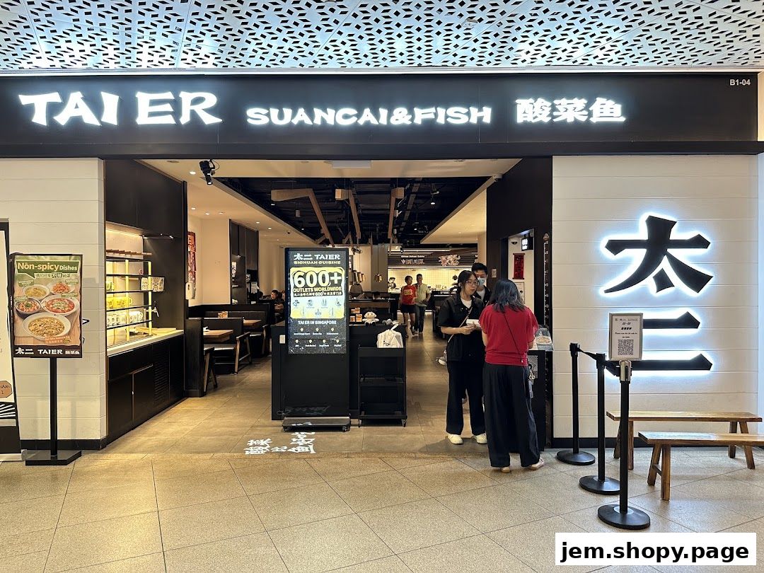 The entrance of the TAI ER SUANCAI&FISH restaurant with signage and people waiting.