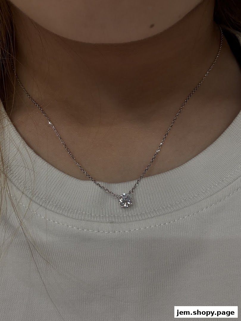 A close-up shot of a delicate diamond pendant necklace on a person's neck.