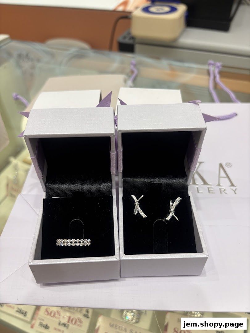 Two jewelry boxes displaying a ring and earrings from TAKA Jewellery.