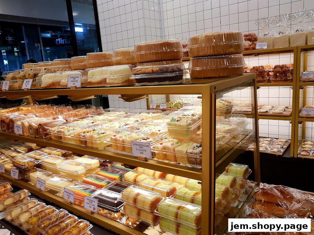 A wide selection of cakes, pastries, and bread displayed on shelves in a bakery.