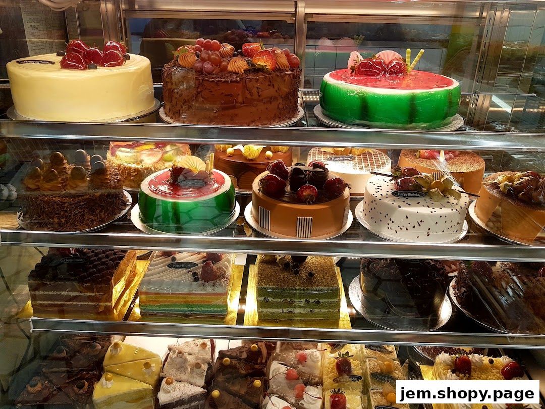 A display case filled with a variety of beautifully decorated cakes, including fruit-topped and novelty designs.