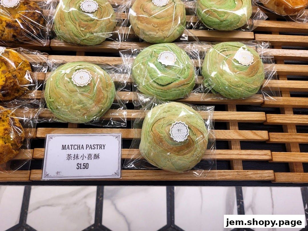 A close-up of matcha pastries displayed on wooden shelves, individually wrapped.