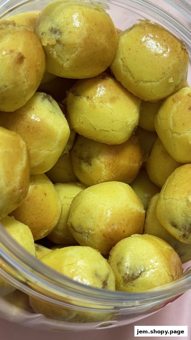 A close-up shot of golden-brown, round pastries filled with a dark filling.