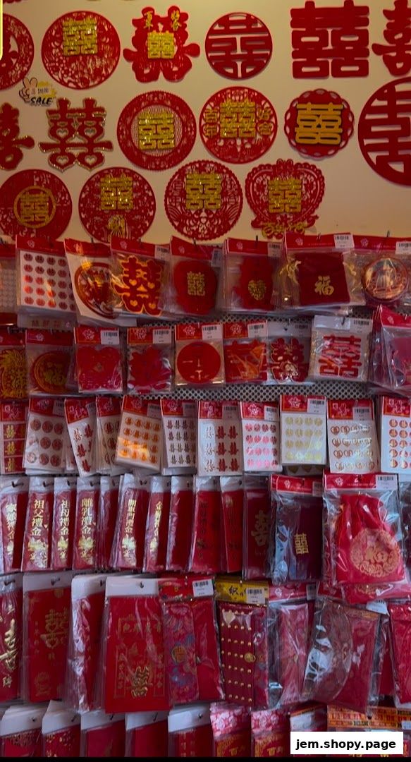 A wall display of red Chinese wedding decorations and gift envelopes.