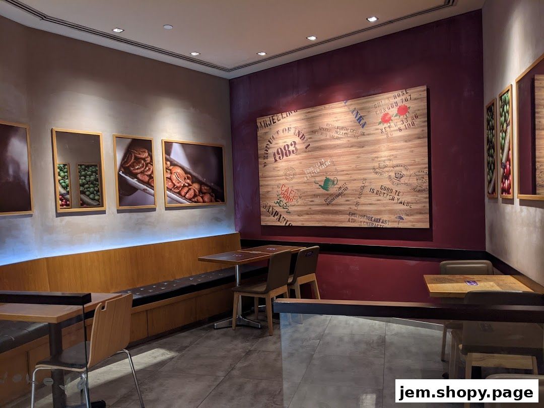Interior of a coffee shop with seating, tables, and coffee-themed wall art.