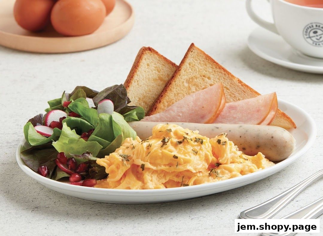 A delicious breakfast platter with scrambled eggs, toast, sausage, and salad.