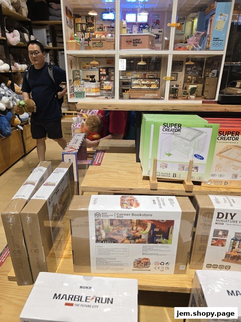 A man looks at a display of miniature DIY dollhouse kits in a retail store.