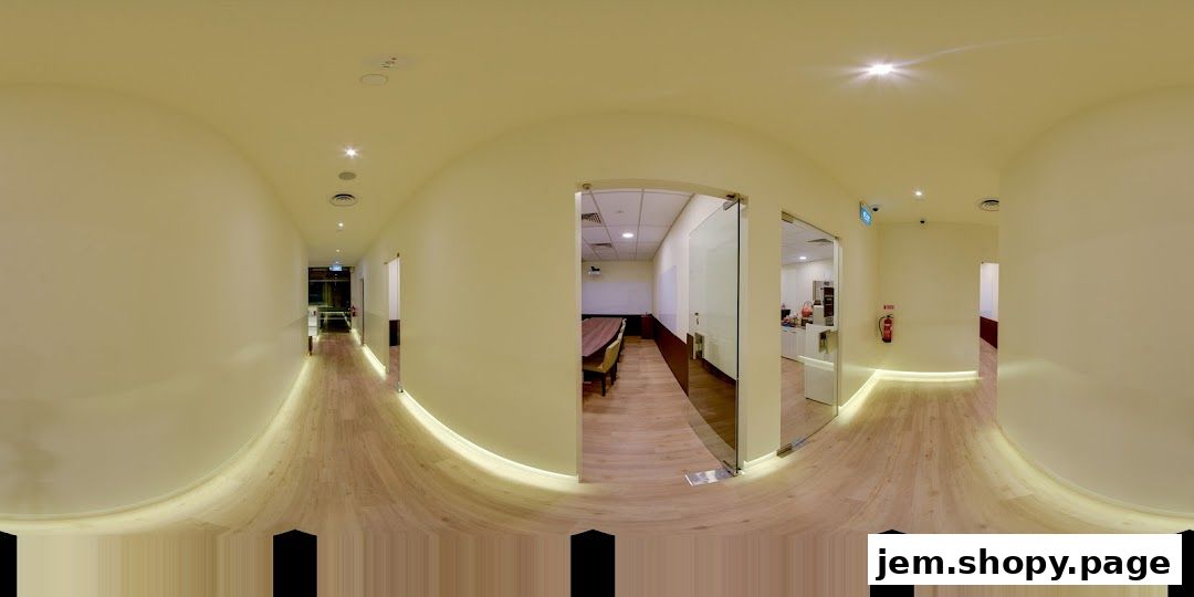 Interior hallway with illuminated baseboards leading to classrooms and meeting rooms.