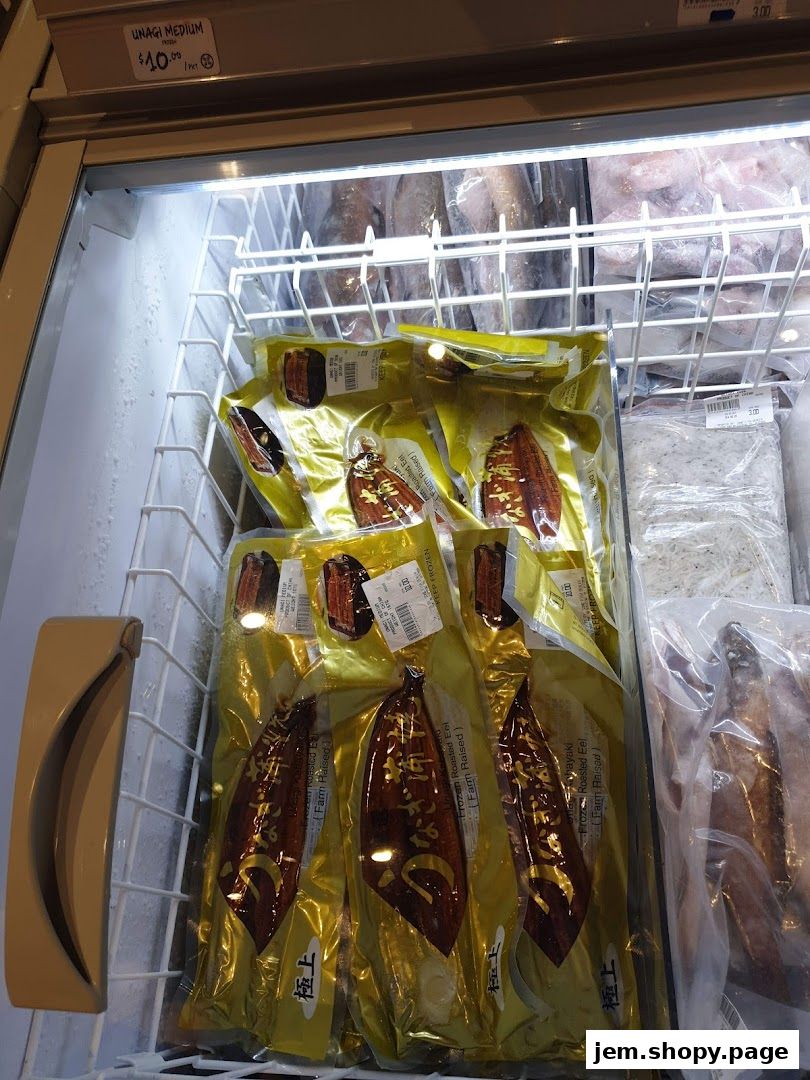 Frozen unagi eel packages displayed in a refrigerated display case.